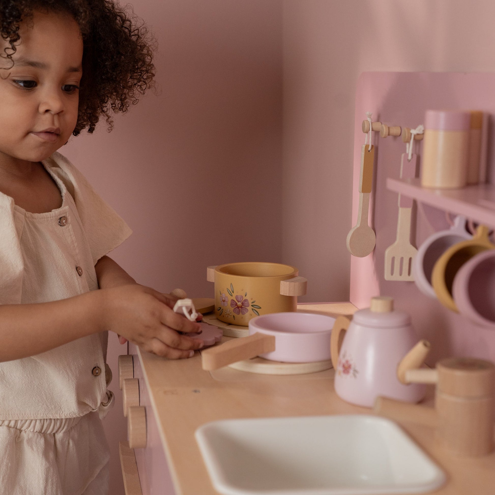 Pretend play pink kitchen with oven, sink, and cupboard