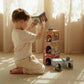 Child playing with Little Dutch stacking boxes and cars