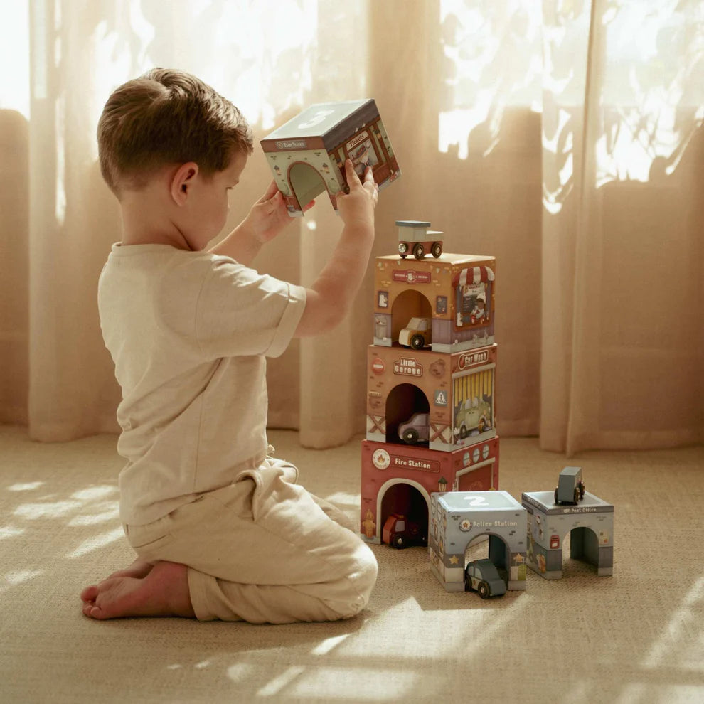 Child playing with Little Dutch stacking boxes and cars