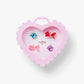 Heart-shaped pink jewelry box with colorful earrings on a white background