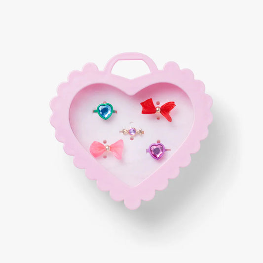 Heart-shaped pink jewelry box with colorful earrings on a white background