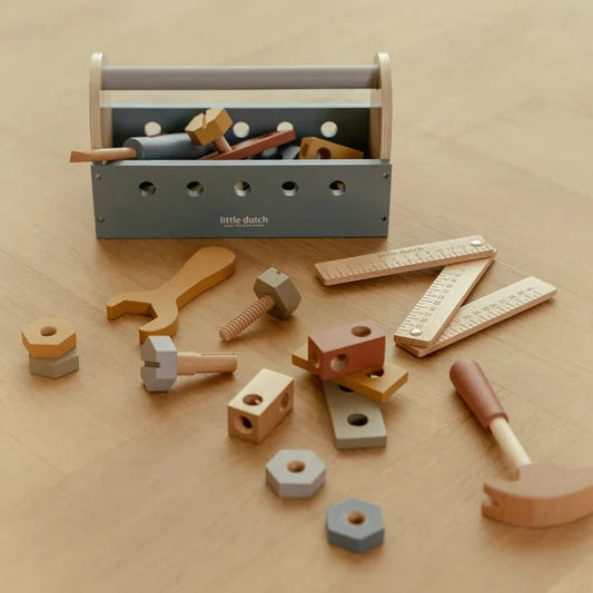 Toy toolbox with various tools on a wooden surface